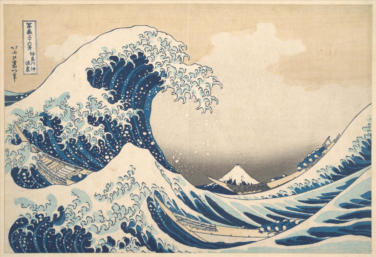 A towering blue wave curls over small boats, with Mount Fuji in the distance.